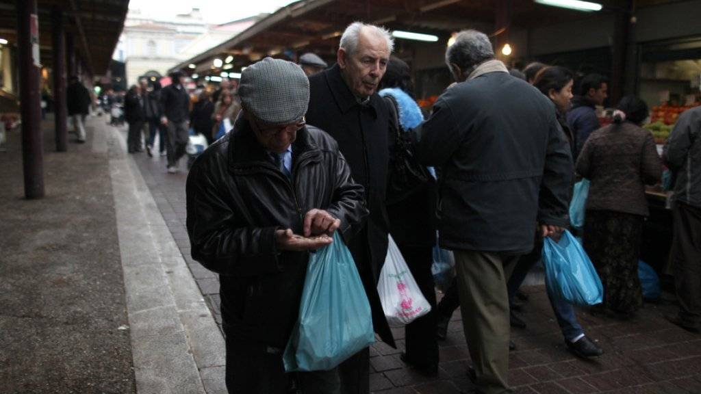 Ein älterer Mann zählt auf dem zentralen Athener Gemüsemarkt nach einem Einkauf seine Euro-Münzen. Laut einer Studie lebt jeder zweite Grieche aufgrund der Krise des Landes unter Angstzuständen, innerer Unruhe und Unsicherheit (Archiv)