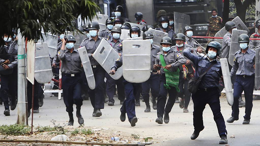 Polizisten stürmen auf Demonstranten in Mandalay zu, um sie zu vertreiben. Foto: --/AP/dpa