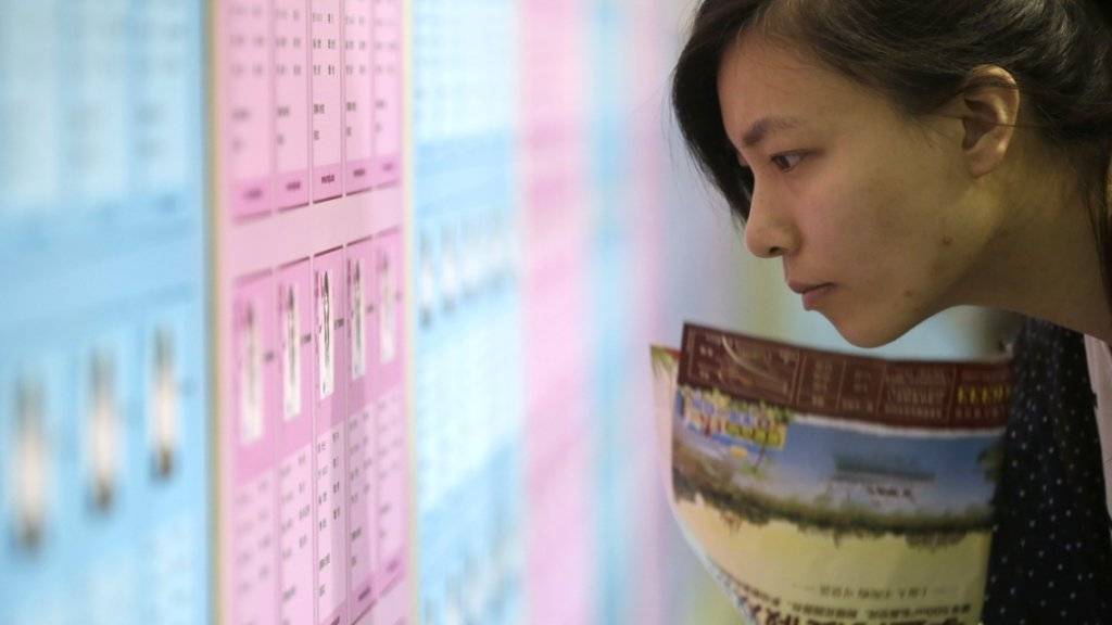 Eine junge Chinesin blickt auf den Aushang einer Partnerbörse: Der «Tag der Singles» wurde in den Neunziger Jahren von Studenten als Antwort auf den Valentinstag ins Leben gerufen (Archiv).