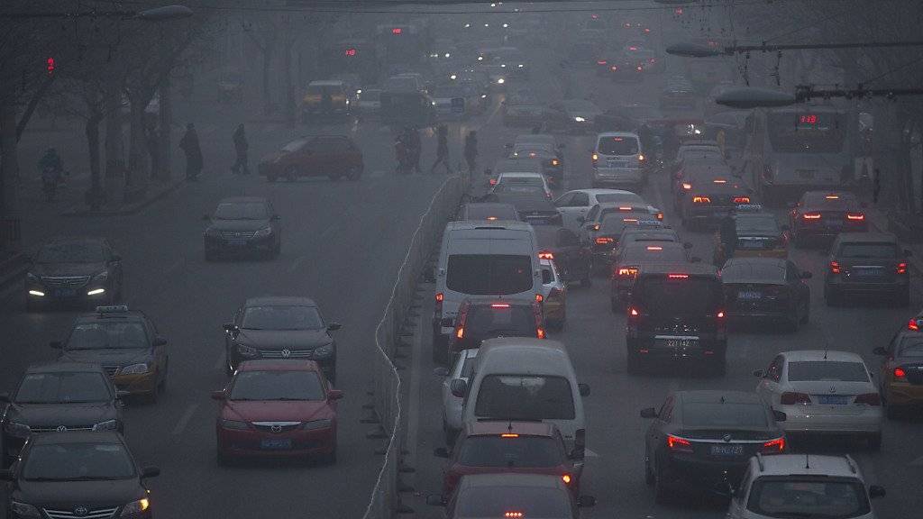Autos fahren durch den Smog von Peking. (Archiv)