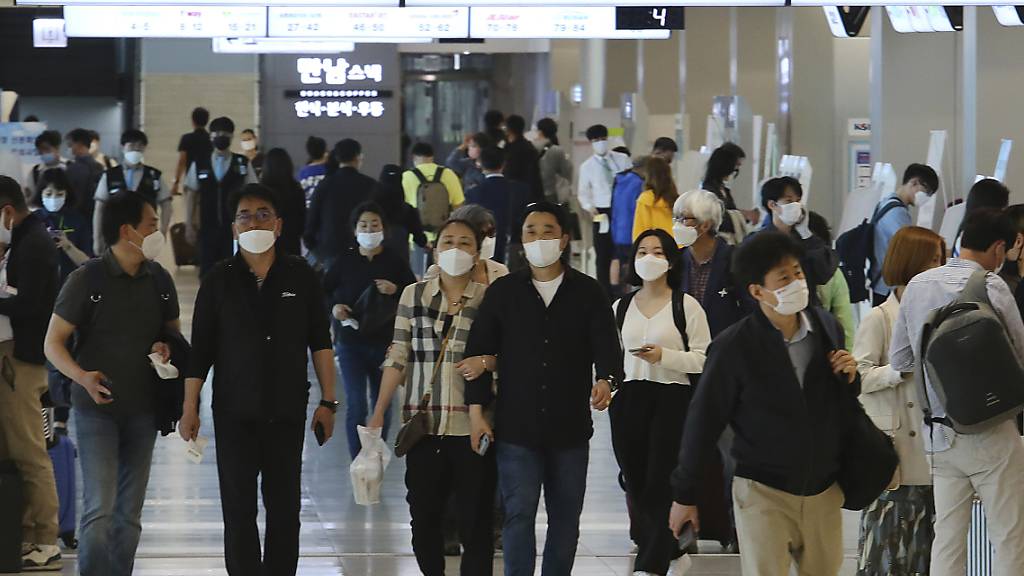 Menschen mit Mundschutz gehen am Flughafen Gimpo durch die Gänge des Inlandsterminals. Die Behörden haben alle Flugzeugpassagiere auf Grund der Corona-Pandemie zum Tragen von Gesichtsmasken aufgefordert. Foto: Ahn Young-Joon/AP/dpa