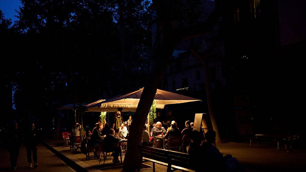 dpatopbilder - Kunden speisen in einem Restaurant, das während eines Stromausfalls von einem Generator beleuchtet wird. Foto: Emilio Morenatti/AP/dpa