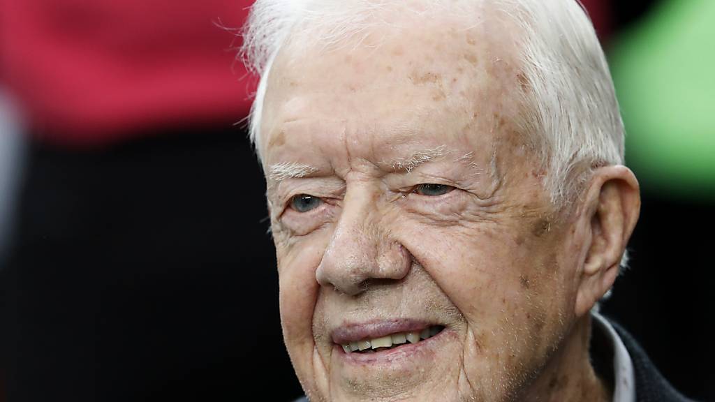 ARCHIV - Der ehemalige US-Präsident Jimmy Carter sitzt während eines NFL-Spiels auf der Bank des NFL-Teams Atlanta Falcons. Foto: John Bazemore/AP/dpa