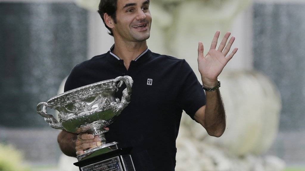 Strahlender Sieger: Roger Federer präsentiert den Pokal am Tag nach seinem Triumph in den Melbourner Carlton Gardens