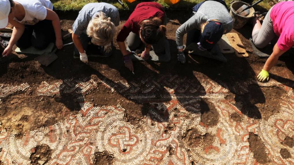 Archäologen legen ein Mosaik frei, das bei Ausgrabungsarbeiten des National Trust an einer römischen Villa in Chedworth entdeckt wurde.
