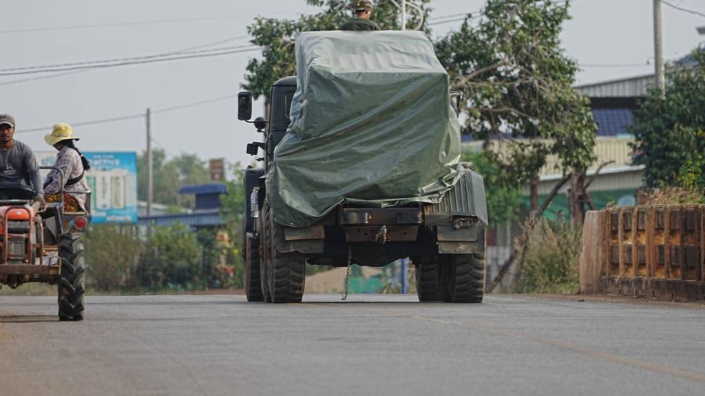 Ein kambodschanisches Militärfahrzeug fährt in Srey Snam in der Provinz Siem Reap an einem Traktor von Evakuierten vorbei. Foto: Heng Sinith/AP/dpa