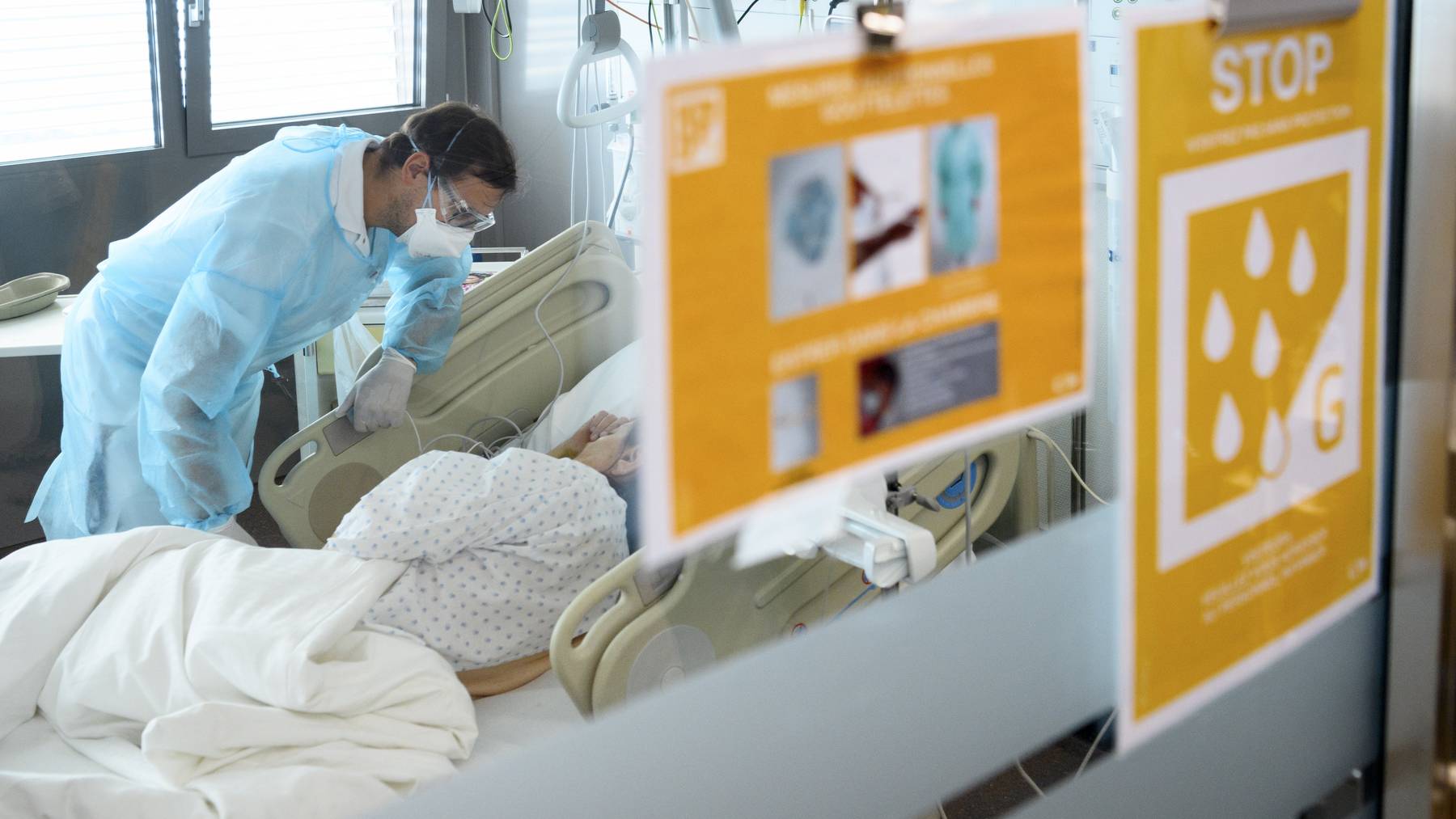 Ein Mitarbeiter betreut im Universitätsspital Lausanne einen am Coronavirus erkrankten Patienten. (Symbolbild)