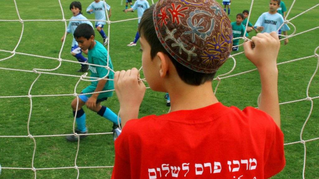 Ein israelischer Junge aus der südlichen Stadt Sderot schaut israelischen und palästinensischen Kindern bei einem gemeinsamen Fussballturnier in Herzliya, nördlich von Tel Aviv zu (Symbolbild)