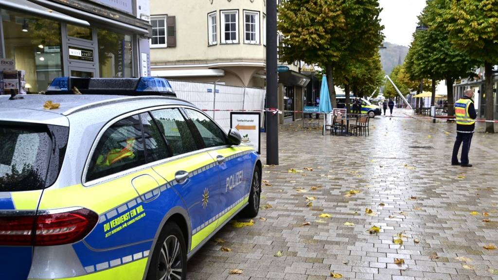 Einsatzkräfte der Polizei stehen vor einem abgesperrten Bereich zu einem Schusswechsel nahe dem Rathaus. Foto: Roland Sprich/dpa