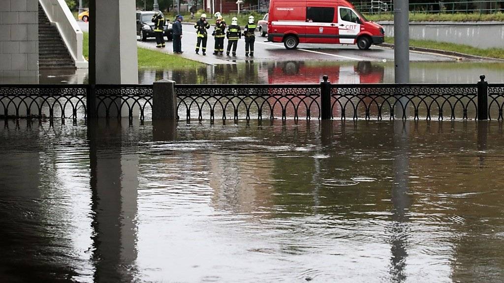 Retter unterstützen die Bewohner Moskaus an überschwemmten Strassen.