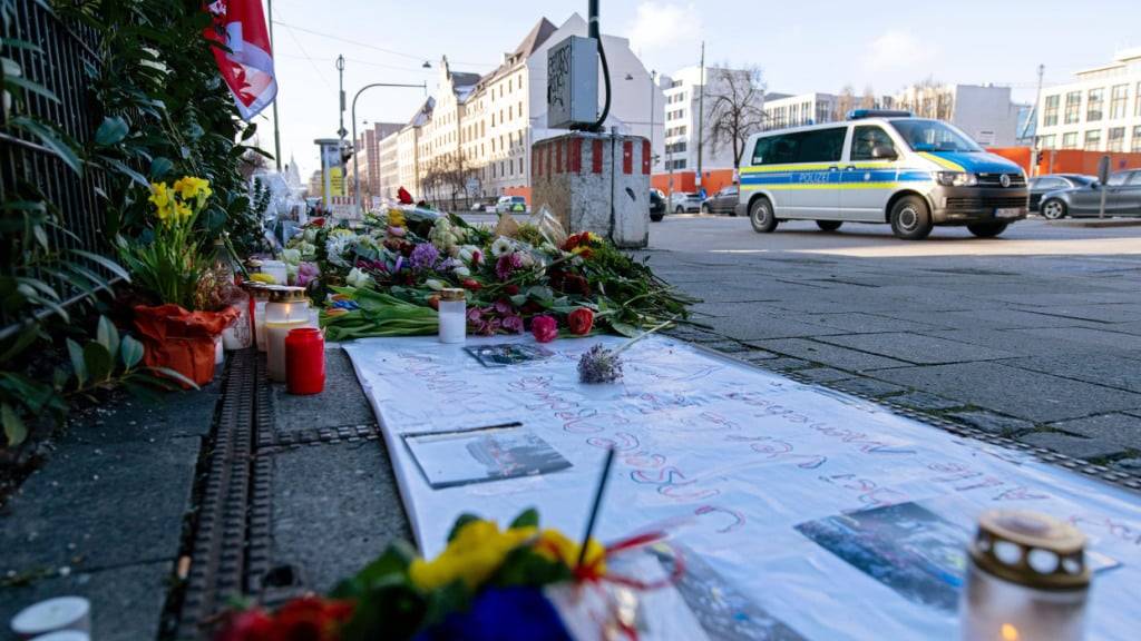ARCHIV - Ein Einsatzfahrzeug der Polizei fährt an Blumen und Kerzen nahe der Stelle in der Innenstadt vorbei, wo am 13.02.2025 ein Auto in eine Gruppe von Demonstranten gefahren war. Foto: Pia Bayer/dpa