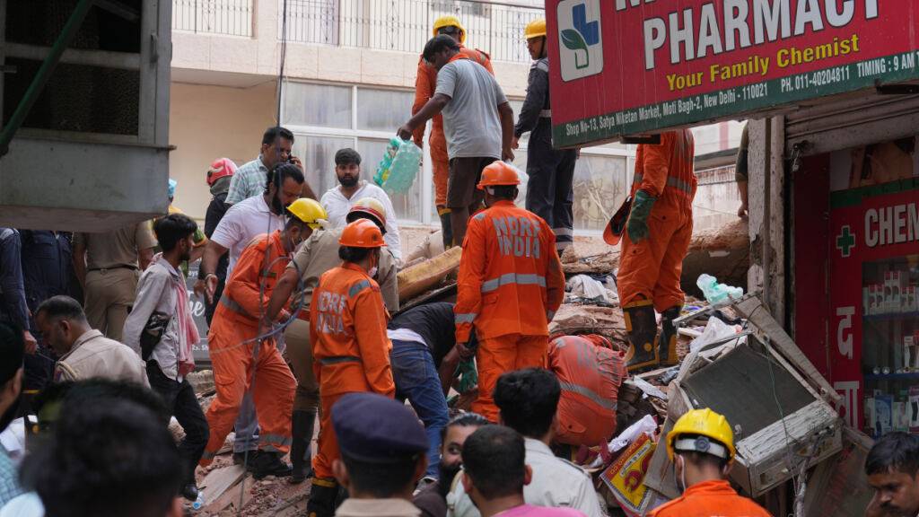 Rettungskräfte suchen in Neu-Delhi unter den Trümmern eines eingestürzten Gebäudes nach Überlebenden. Foto: Rajesh Kumar Singh/AP/dpa