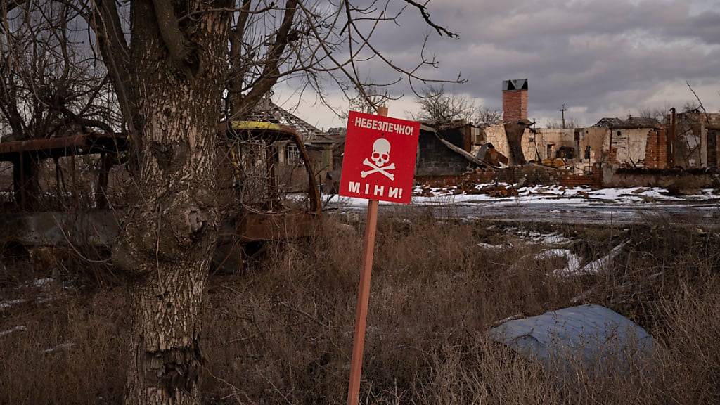 ARCHIV - Ein Schild mit der Aufschrift «Minen» steht am Straßenrand des Dorfes Kamjanka am Rande von Isjum. Foto: Vadim Ghirda/AP