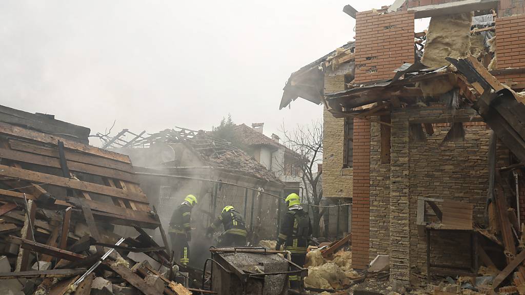 ARCHIV - Feuerwehrleute beseitigen die Folgen eines Raketenangriffs durch russische Truppen. Foto: ---/https: