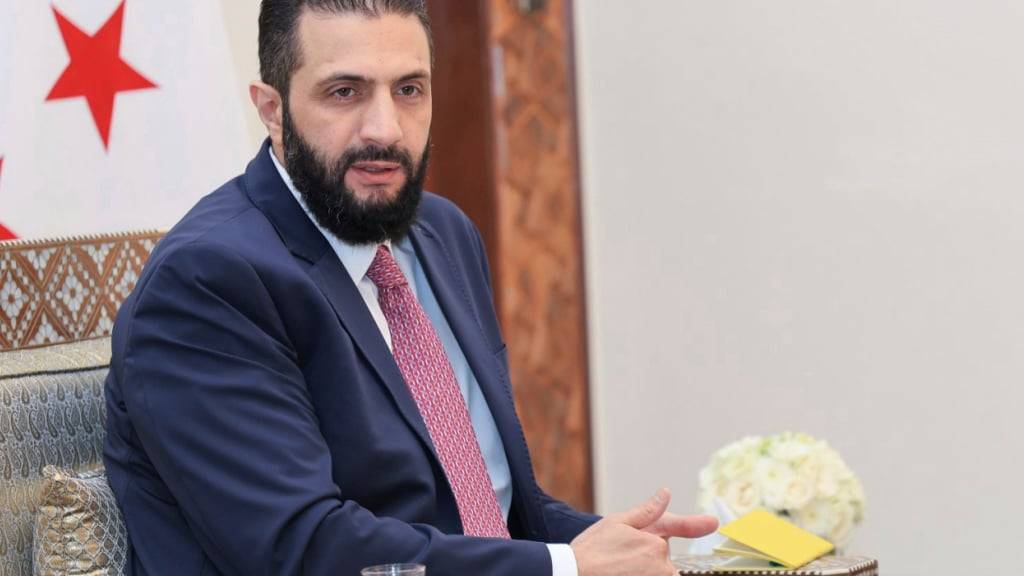 Auf diesem von der amtlichen syrischen Nachrichtenagentur SANA via AP veröffentlichten Foto erhält der syrische Interimspräsident Ahmad al-Sharaa die endgültige Fassung des vorläufigen Wahlsystems für die Volksversammlung. Foto: Uncredited/SANA/AP/dpa