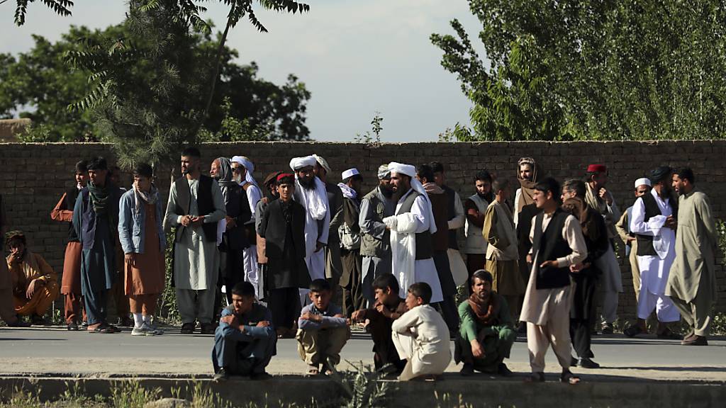 Menschen versammeln sich in der Nähe einer Moschee nach einer Bombenexplosion in Kabul. Bei dem Anschlag sind nach Angaben der Polizei mindestens zwölf Menschen getötet worden. Foto: Rahmat Gul/AP/dpa