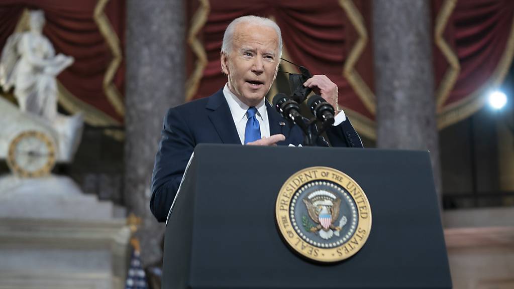 Joe Biden, Präsident der USA, nimmt seinen Mund-Nasen-Schutz ab, während er in der Statuary Hall des US-Kapitols anlässlich des Jahrestags der Erstürmung des US-Kapitols spricht. Foto: Greg Nash/Pool The Hill/Pool/AP/dpa