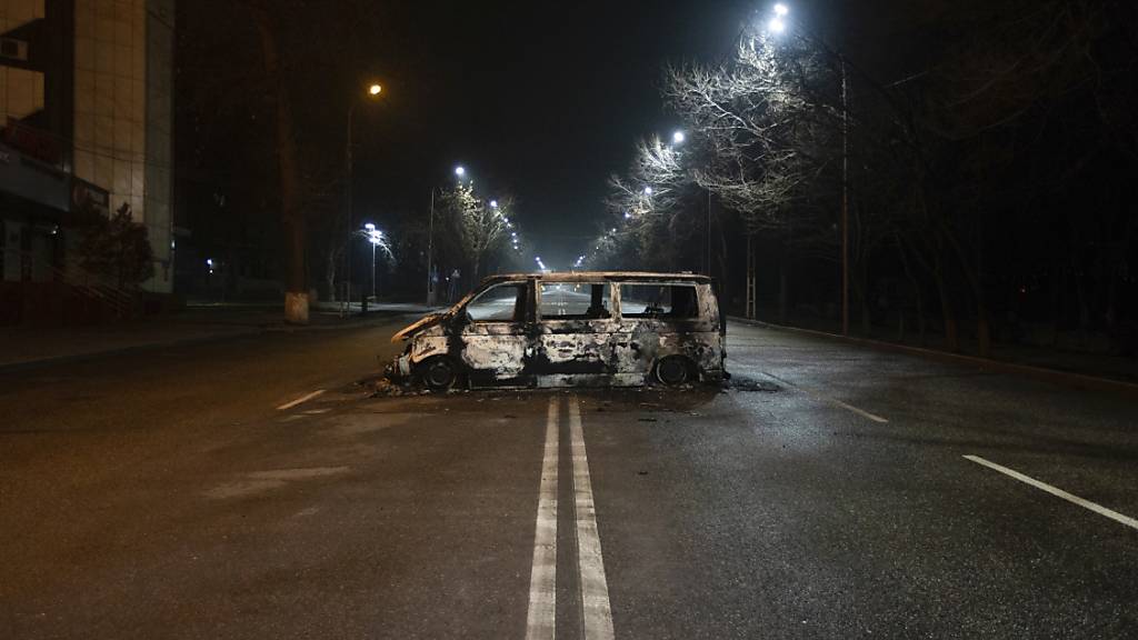 Ein verbrannter Polizeibus steht am Abend auf einer leeren Straße in Almaty. Die Ausschreitungen in der kasachischen Metropole haben wohl schwere Verwüstungen hinterlassen. Das schilderte ein vor Ort lebender Journalist der Deutschen Presse-Agentur am Sonntag am Telefon. Foto: Vasily Krestyaninov/AP/dpa