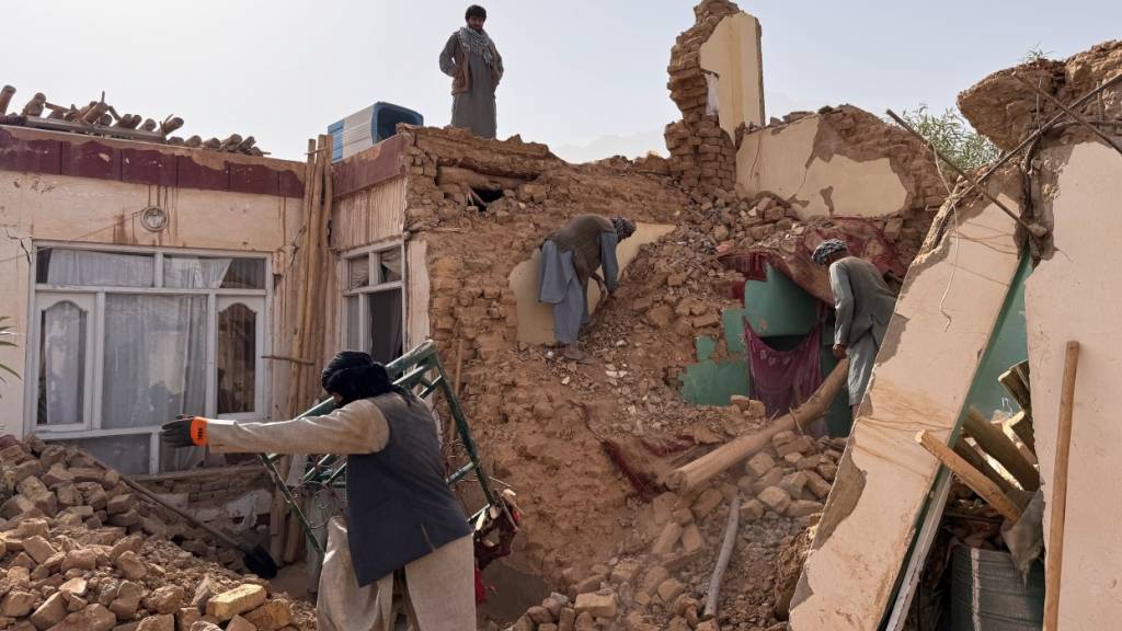 Einheimische suchen in den Trümmern eines zerstörten Hauses nach einem Erdbeben der Stärke 6,3 in einer ländlichen Gegend des Bezirks Khulm im Norden Afghanistans. Foto: Sirat Noori/AP/dpa