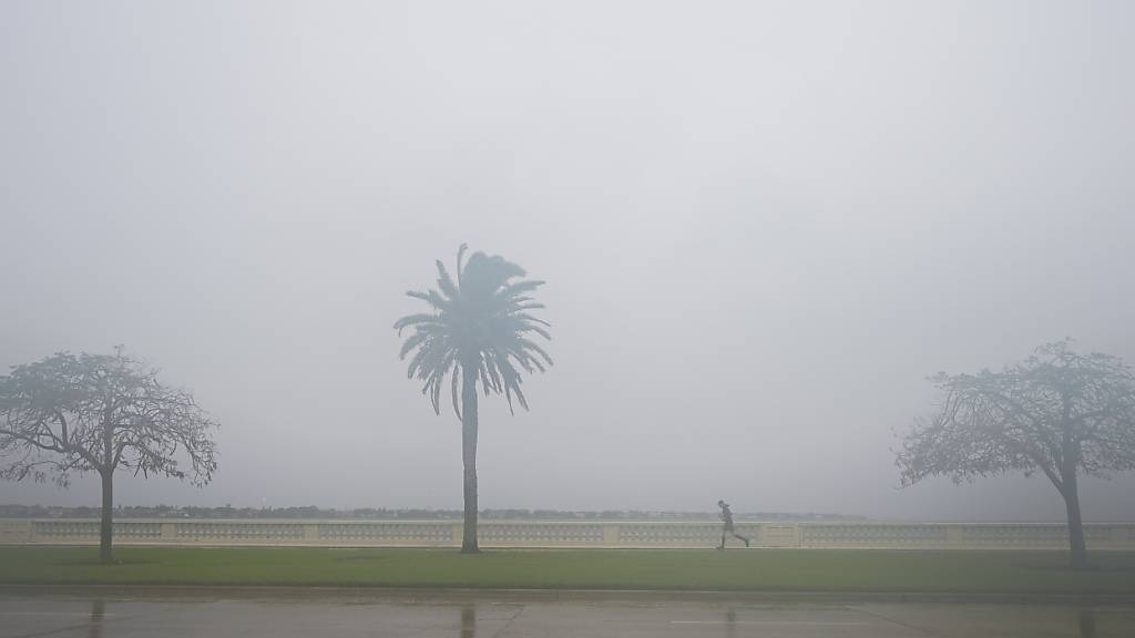 Ein Jogger läuft in Tampa, Florida, durch den Regen vor der Ankunft des Hurrikans «Milton». Foto: Julio Cortez/AP/dpa