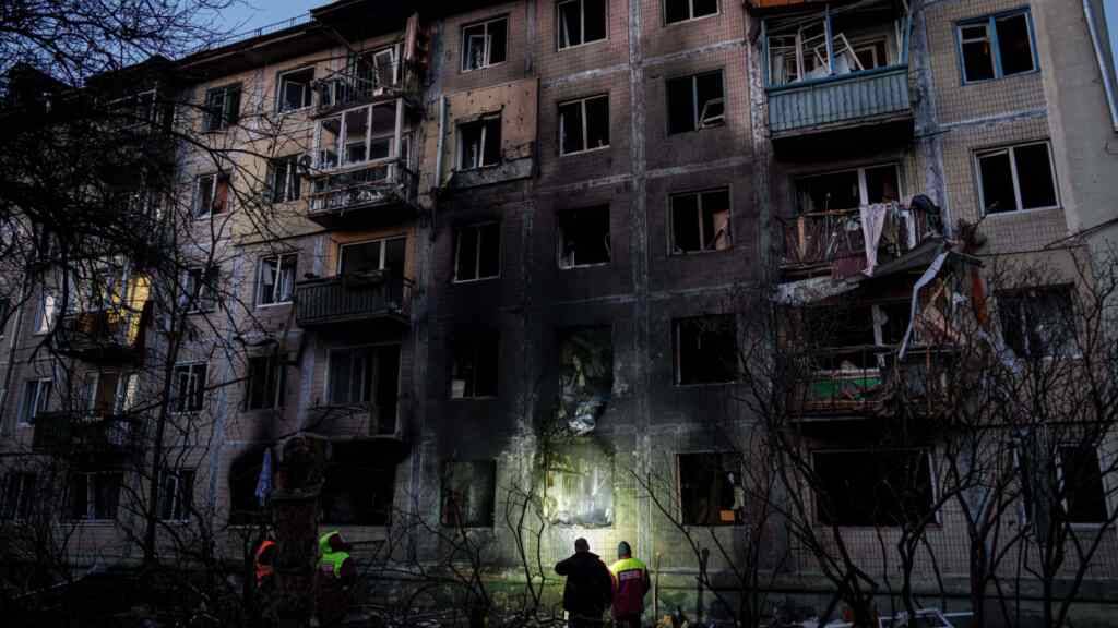 dpatopbilder - Arbeitskräfte der örtlichen Behörden betrachten ein Wohnhaus, das nach einem russischen Angriff auf Kiew beschädigt wurde. Foto: Evgeniy Maloletka/AP/dpa