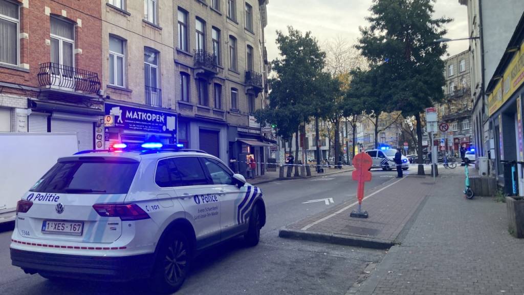 Die Polizei sperrt eine Straße. Nach den tödlichen Schüssen auf zwei Schweden in Brüssel hat die belgische Polizei einen bewaffneten Verdächtigen niedergeschossen. Ob es sich dabei um den Täter handelt, war einem Sprecher der Bundesstaatsanwaltschaft zufolge zunächst unklar. Foto: Lou Lampaert/Belga/dpa