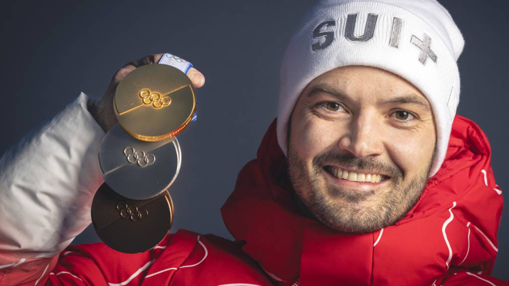 Loïc Meillard posiert mit seinen drei in Bormio gewonnenen Olympia-Medaillen