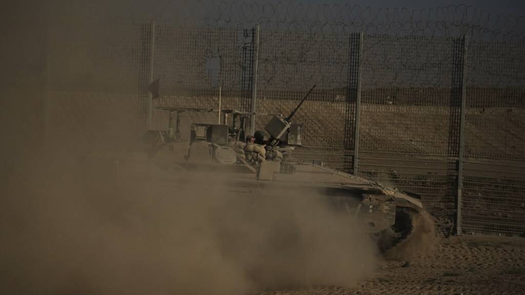 Ein israelisches gepanzertes Fahrzeug bewegt sich entlang der Grenze zwischen Israel und Gaza, vom Süden Israels aus gesehen. Foto: Leo Correa/AP/dpa