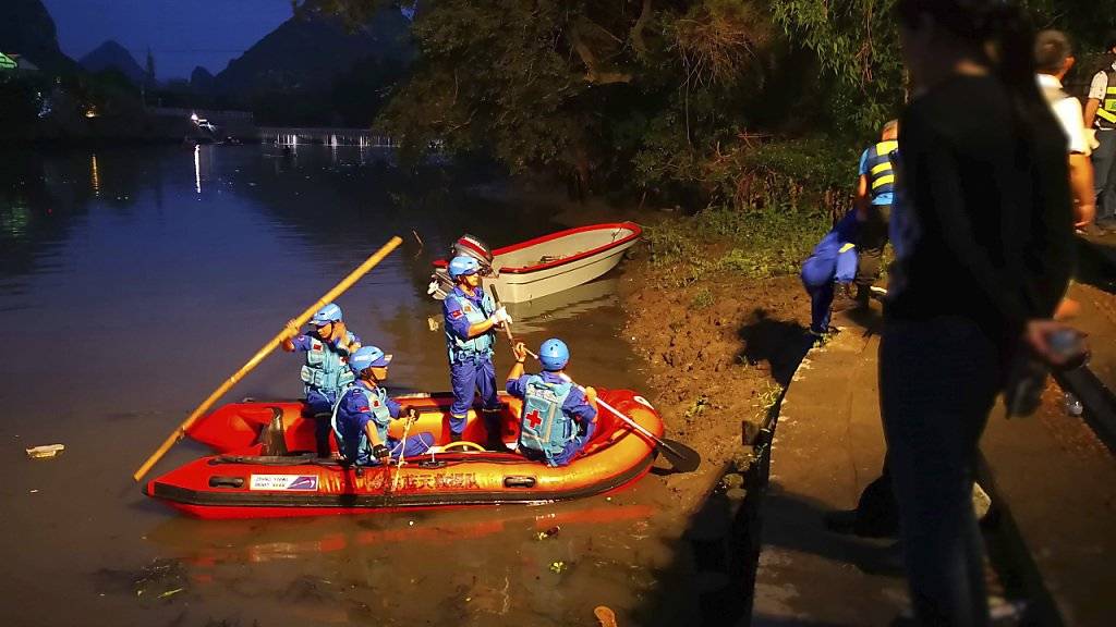 Rettungskräfte suchen nach dem Bootsunfall nach verunfallten Personen. Das Unglück passierte beim Training für die jährlichen Rennen zum Drachenbootfest.