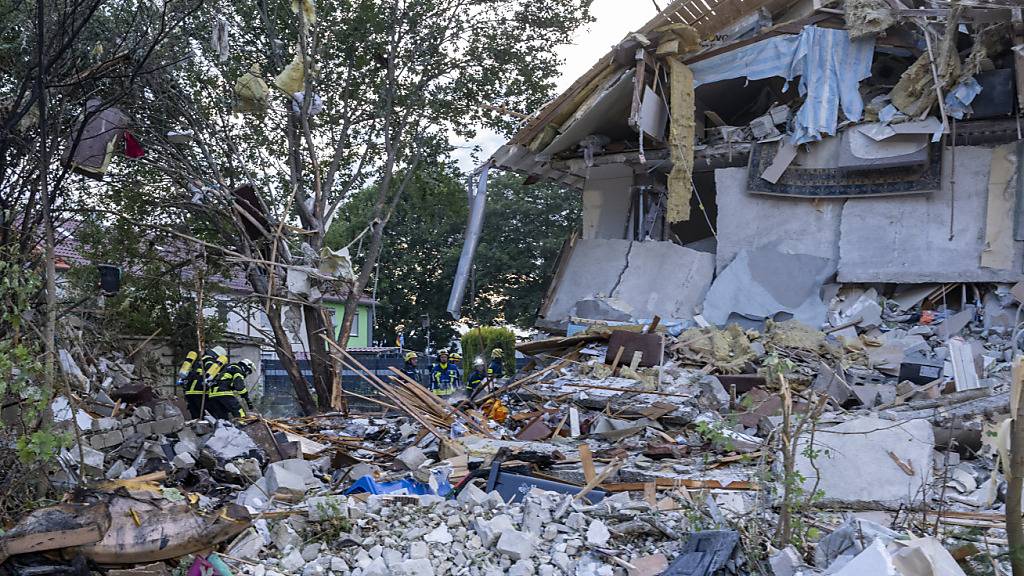 Rettungskräfte arbeiten an der Unglücksstelle. In Bayern ist der Polizei zufolge nach einer Explosion ein Reiheneckhaus eingestürzt. Ob Menschen in dem Gebäude in Memmingen waren, ist noch unklar. Foto: Stefan Puchner/dpa