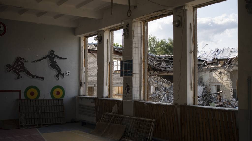 In Kupiansk ist durch die zerbrochenen Fenster einer Turnhalle die zerstörte Bibliothek einer Schule zu sehen. Foto: Bram Janssen/AP