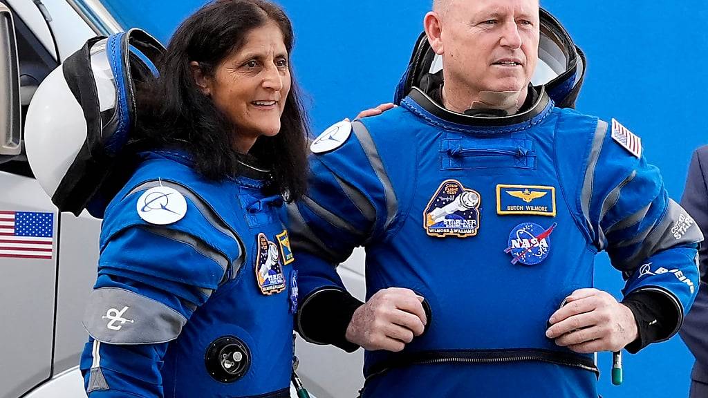 ARCHIV - Die Nasa-Astronauten Suni Williams (l) und Barry ‹Butch› Wilmore unterhalten sich mit Familienmitgliedern. Foto: John Raoux/AP/dpa