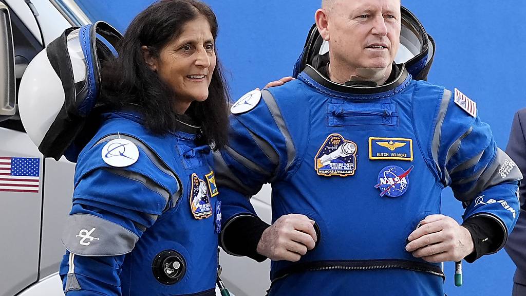 ARCHIV - Die Nasa-Astronauten Suni Williams (l) und Barry ‹Butch› Wilmore unterhalten sich mit Familienmitgliedern. Foto: John Raoux/AP/dpa