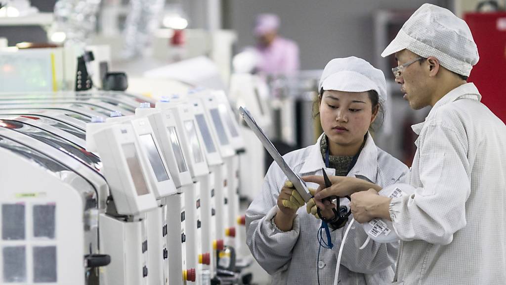 Chinas Industrie hat 2020 trotz der Pandemie höhere Gewinne erzielt. Im Bild: Arbeiter in einer Fabrik im chinesischen Guiyang, in der Smartphones herstellt werden. (Symbolbild)