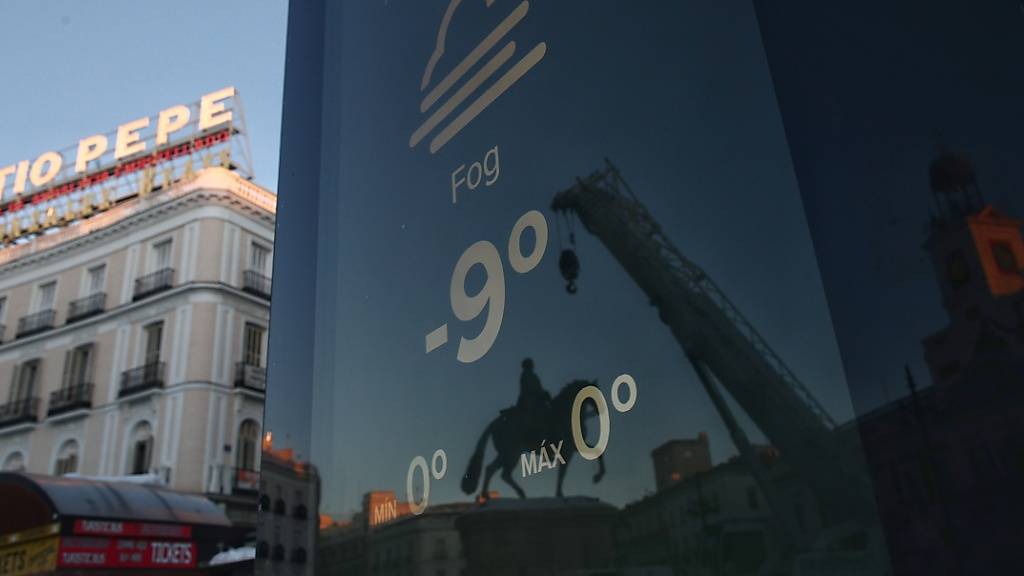 Ein Bildschirm an der Puerta del Sol in Madrid zeigt eine Temperatur von minus 9 Grad an.