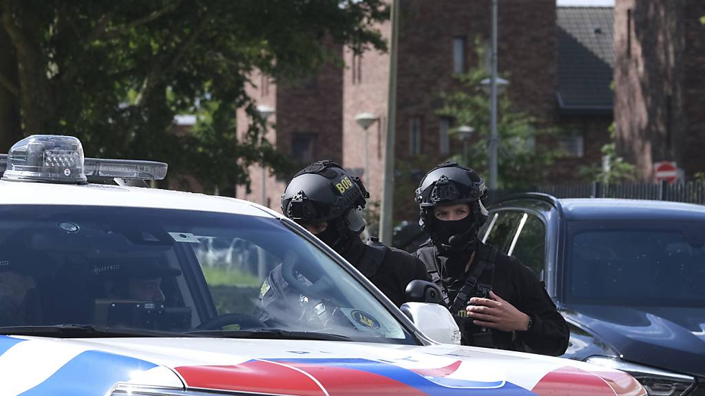 dpatopbilder - Bewaffnete Polizisten patrouillieren vor dem Amsterdamer Gerichtsgebäude, wo die Urteile im Prozess gegen neun Männer verkündet werden, die verdächtigt werden, an der Ermordung des beliebten Journalisten Peter R. de Vries vor drei Jahren auf einer belebten Amsterdamer Straße beteiligt gewesen zu sein. Foto: Mike Corder/AP