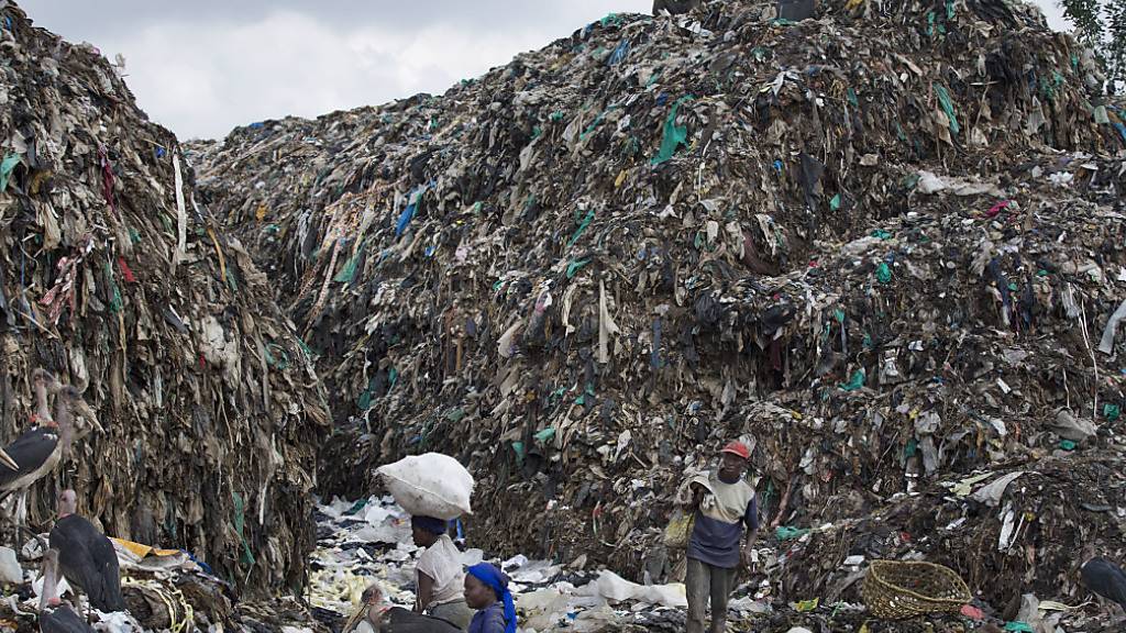 ARCHIV - Menschen durchsuchen im Dandora Slum einen Müllberg und suchen nach wiederverwertbaren Gegenständen. Bei der Ausarbeitung eines weltweit verbindlichen Abkommens zur Eindämmung von Plastikmüll haben verhandelnde Staaten nach Angaben von Teilnehmern kaum Fortschritte machen können. Foto: Ben Curtis/AP/dpa