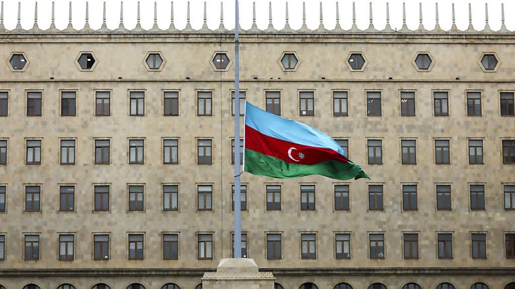 Die aserbaidschanische Nationalflagge weht vor einem Regierungsgebäude auf Halbmast zum Gedenken an die Opfer der Embraer 190 der Azerbaijan Airlines, die in der Nähe des kasachischen Flughafens Aktau abgestürzt ist. Foto: Aziz Karimov/AP/dpa