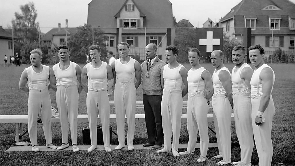Die Schweizer Nationalmannschaft der Kunstturner im Jahre 1936 mit August Güttinger (in Zivil) und Georges Miez (links von Güttinger)
