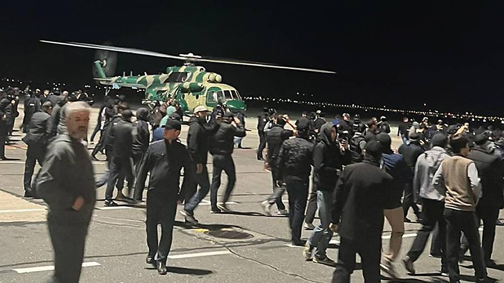 Menschen rufen antisemitische Parolen auf einem Flugfeld des Flughafens in Machatschkala. Foto: Uncredited/AP/dpa