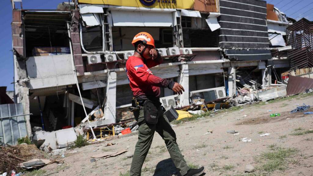 dpatopbilder - Ein Retter geht an einem beschädigten Gebäude nach einem Erdbeben vorbei. Foto: Basilio Sepe/AP/dpa