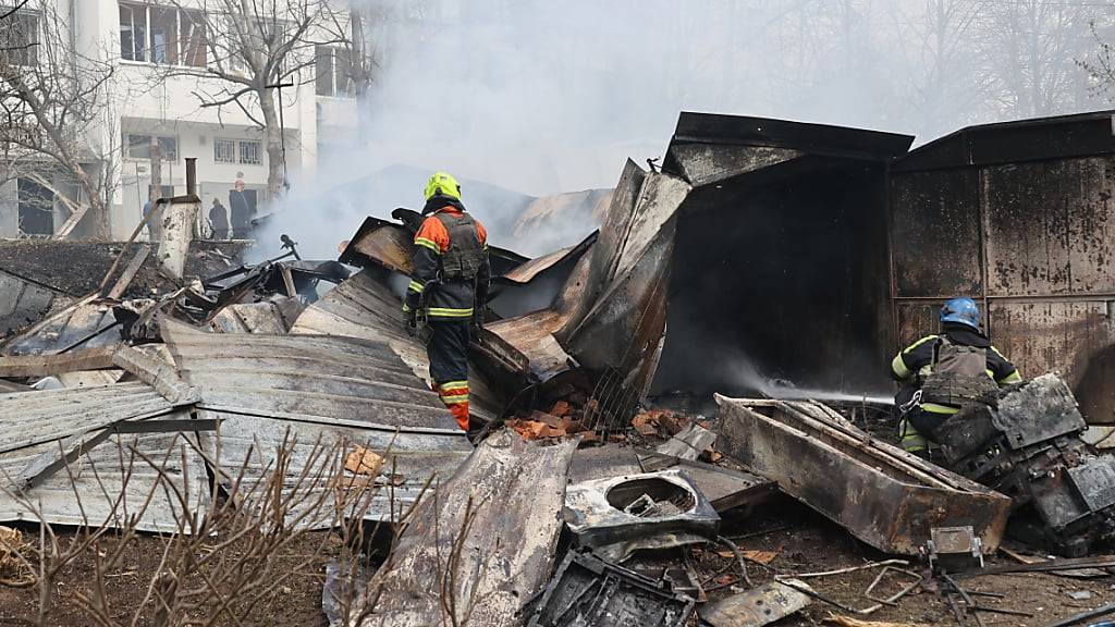 Feuerwehrleute löschen ein Feuer nachdem eine russische Präzisionsmunition zivile Infrastrukturen in Charkiw im Nordosten der Ukraine getroffen hat. Foto: -/Ukrinform/dpa