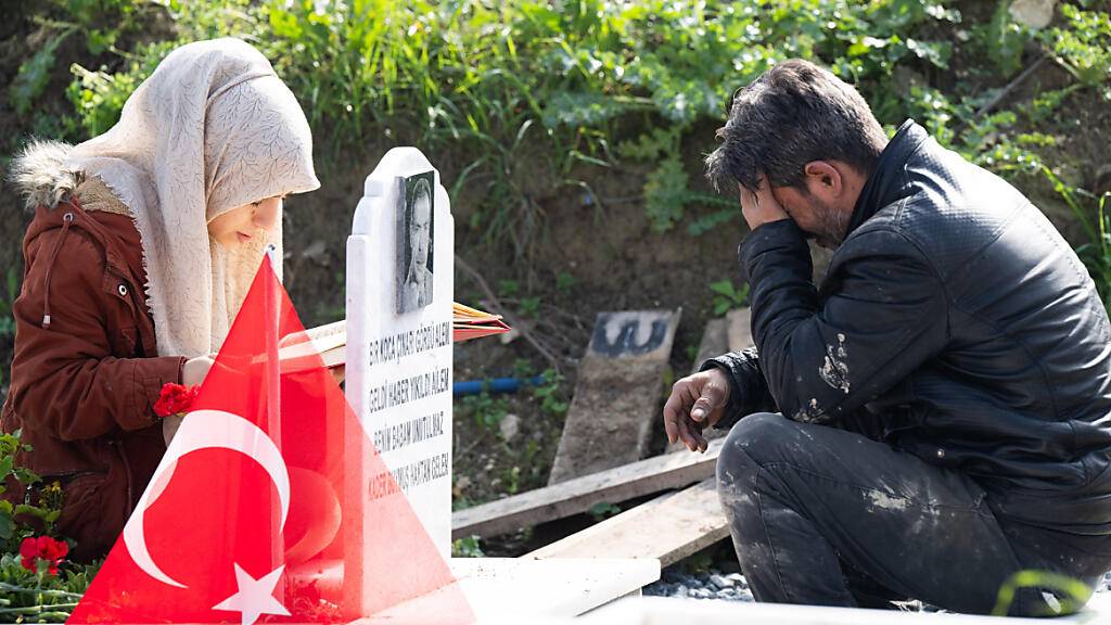 Trauernde beten am Grab eines Familienmitglieds auf einem Friedhof in Antakya. Foto: Boris Roessler/dpa