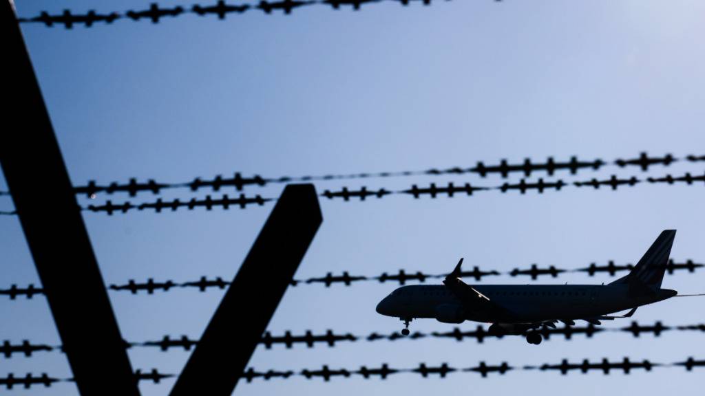 ARCHIV - Ein Flugzeug mit abgeschobenen Migranten fliegt hinter Stacheldraht am Flughafen Hannover. Foto: Julian Stratenschulte/dpa/Symbolbild