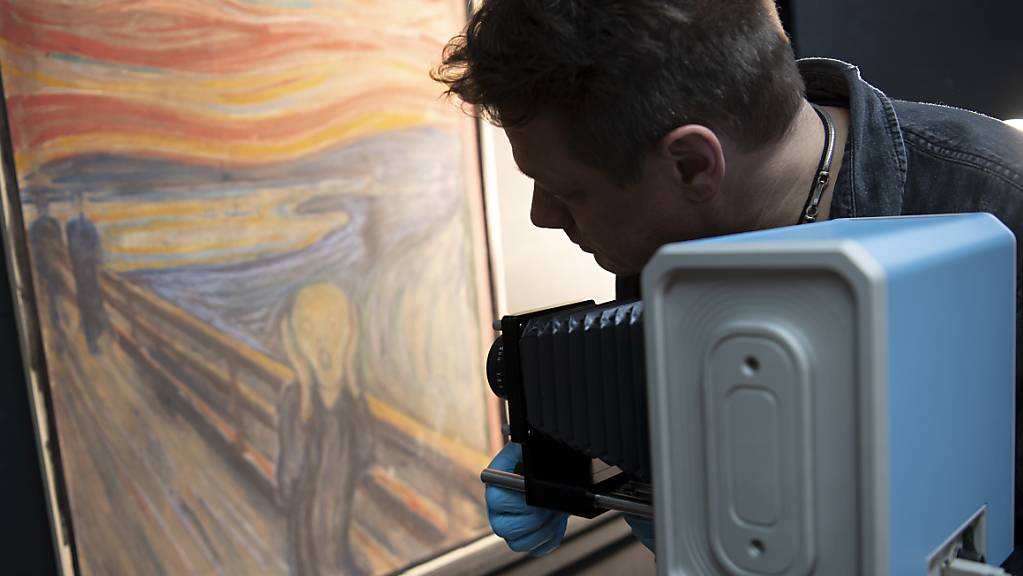 Ein Mann richtet eine Infrarotkamera auf das Gemälde «Der Schrei» von Edvard Munch. 
