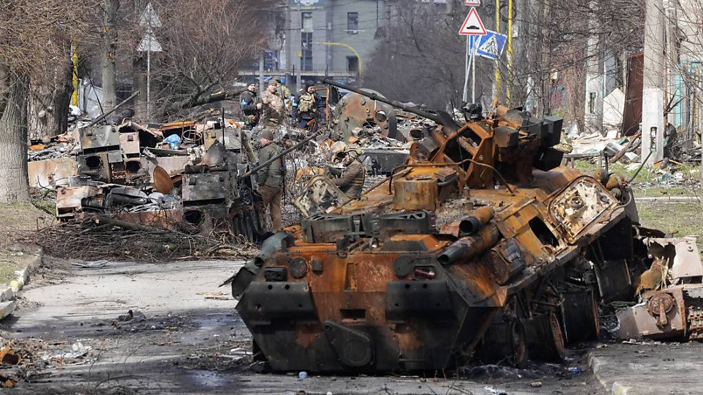 Ukrainische Soldaten untersuchen zerstörte russische Militärfahrzeuge nach einem Gefecht in Butscha