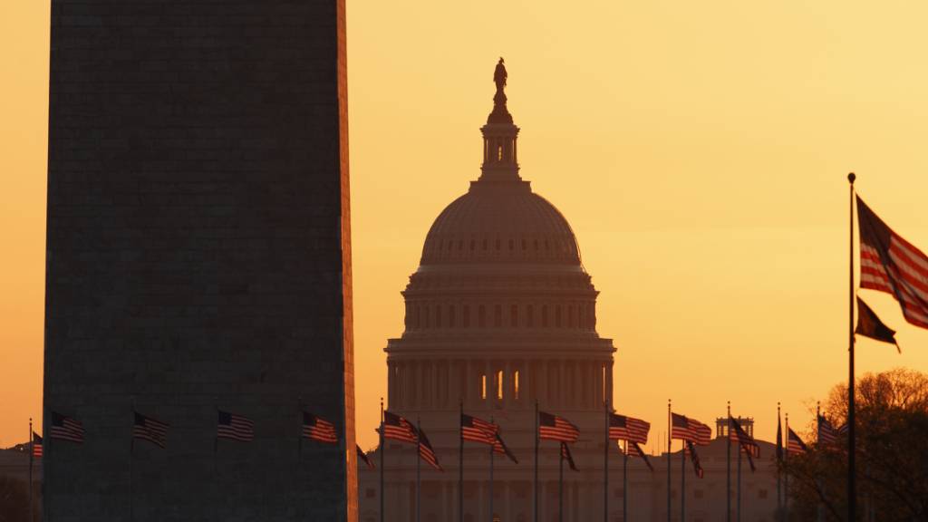 ARCHIV - Das Washington Monument (l) und das Kapitol (M) sind bei Sonnenaufgang zu sehen. Das US-Repräsentantenhaus hat das Veto des amtierenden Präsidenten Trump gegen den Verteidigungshaushalt überstimmt. Foto: Carolyn Kaster/AP/dpa