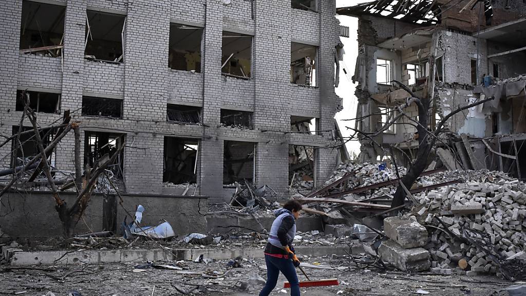 Ein Anwohner fegt Trümmer in der Nähe eines bei einem russischen Luftangriff beschädigten Gebäudes in der Stadt Orikhiv, Region Saporischschja, Ukraine. Foto: Andriy Andriyenko/AP/dpa