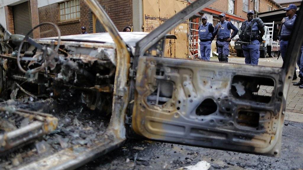 Polizisten sichern nach Ausschreitungen eine Strasse in Johannesburg. Zahlreiche Geschäfte von Einwanderern wurden geplündert, grosse Schäden angerichtet.