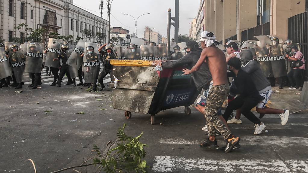 Demonstranten stoßen mit der Polizei auf einer Straße in Lima, Peru, zusammen. Foto: Aldair Mejia/AP/dpa
